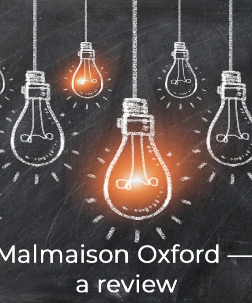 A chalk board with lightbulbs drawn in chalk and the words Malmaison Oxford written underneath
