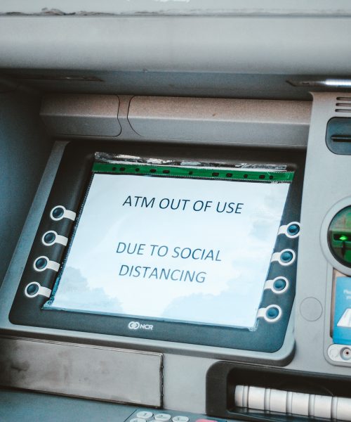 An ATM machine displays a sign saying ATM out of use due to social distancing